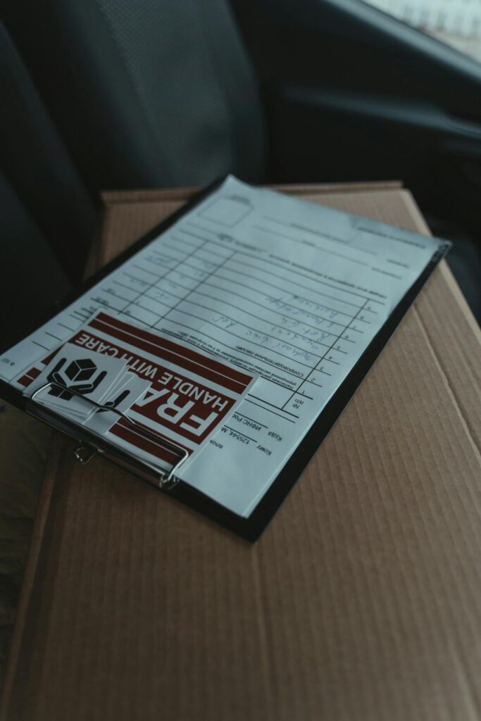 Close-up of a clipboard with documents on a package inside a vehicle, signaling delivery service.